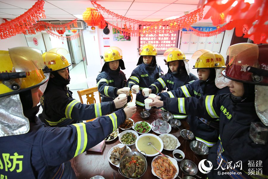 漳州消防特勤大隊一中隊消防指戰(zhàn)員歡聚一堂，吃年夜飯，舉杯共飲。