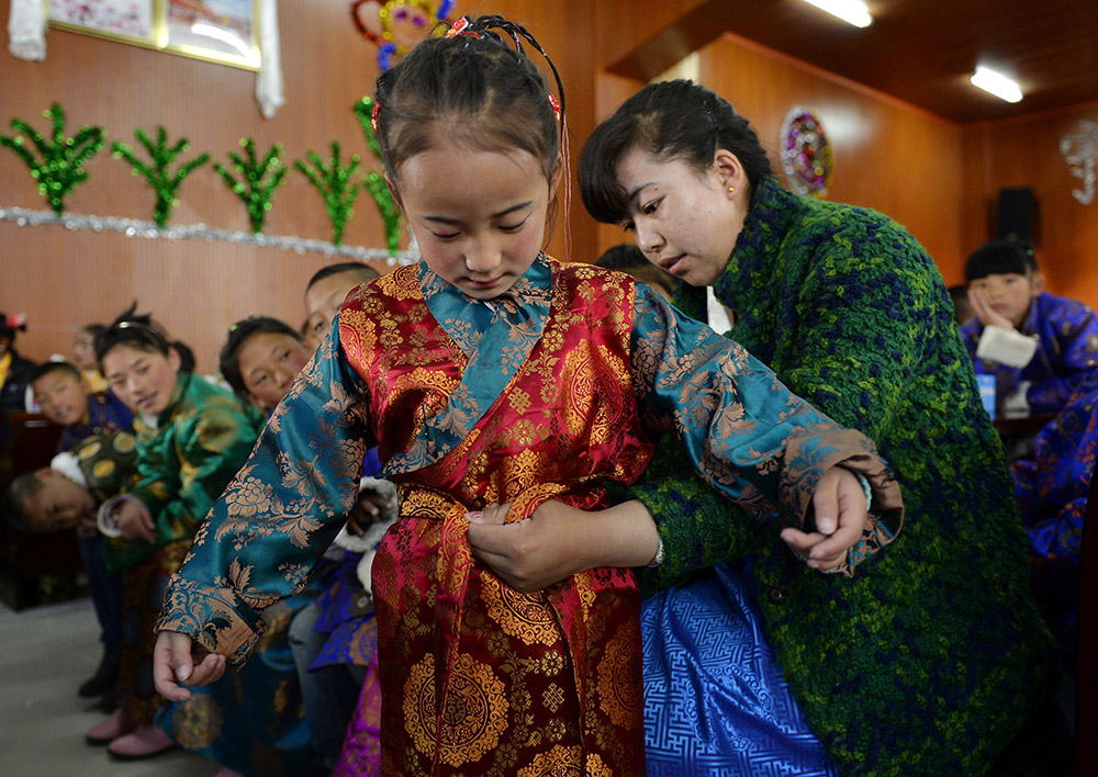 2月27日，在西藏自治區(qū)兒童福利院，來自拉薩市尼木縣的“愛心媽媽”德慶旺姆（右）在為來自那曲地區(qū)的嘎瑪曲宗換上節(jié)日盛裝。